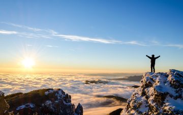 Man standing on a mountain at sunrise